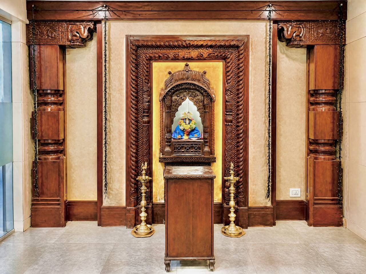 The carved wooden shrine with brass lamps in THC Hospital's lobby